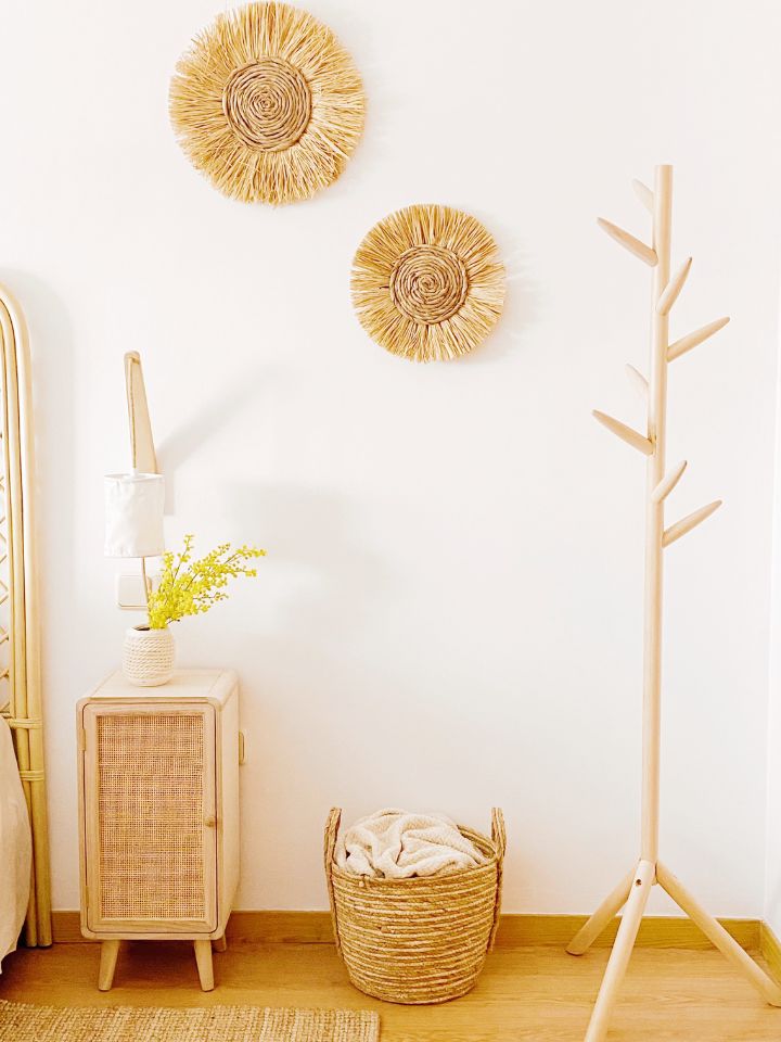 decoración de pared en rafia, perchero de madera y mesilla de fibras naturales
